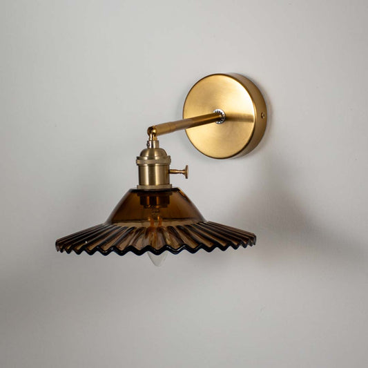 Amber glass wall sconce with gold metal base light off on white background perfect for bedroom and living room wall decor.