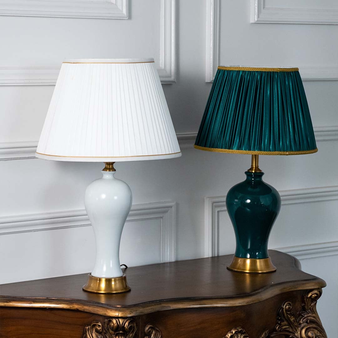 White and green ceramic table lamps turned off with gold bases and pleated shades displayed together showcasing color options for stylish living room or bedroom lighting.