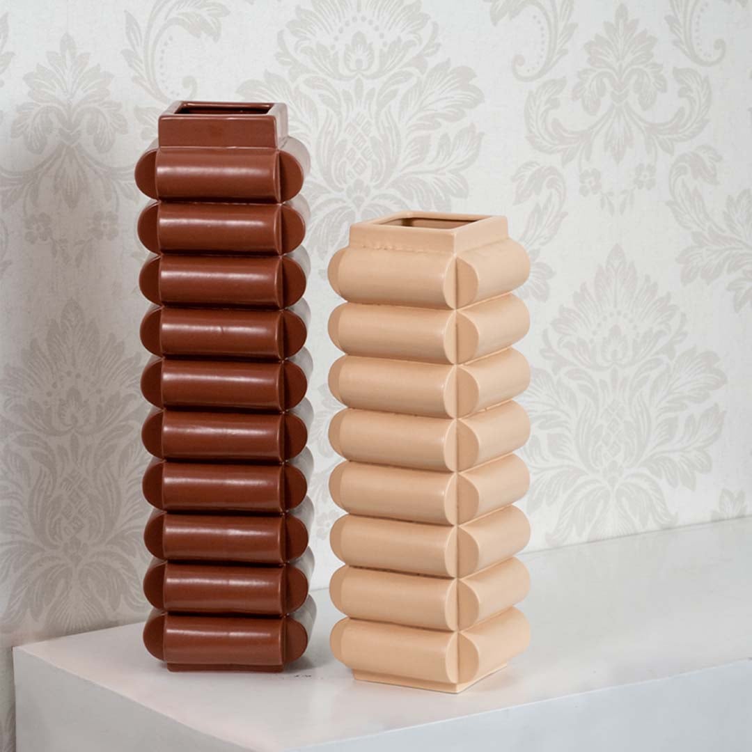Grouped sculptural ceramic vases in brown and beige tones styled together on tabletop adding modern decor accent to interiors.