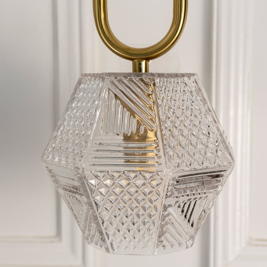 Closeup of geometric crystal pendant light with gold frame showcasing intricate craftsmanship and brilliance.