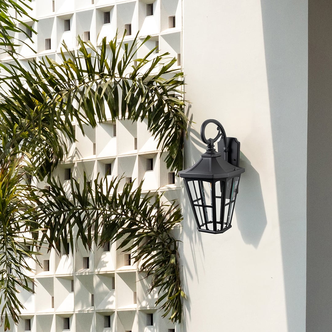 Stylish lantern gate light mounted near wrought iron gate for elegant outdoor lighting.