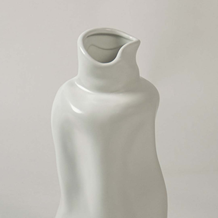 Closeup view of a white ceramic sculptural vase highlighting its smooth artistic curves and modern handcrafted design.
