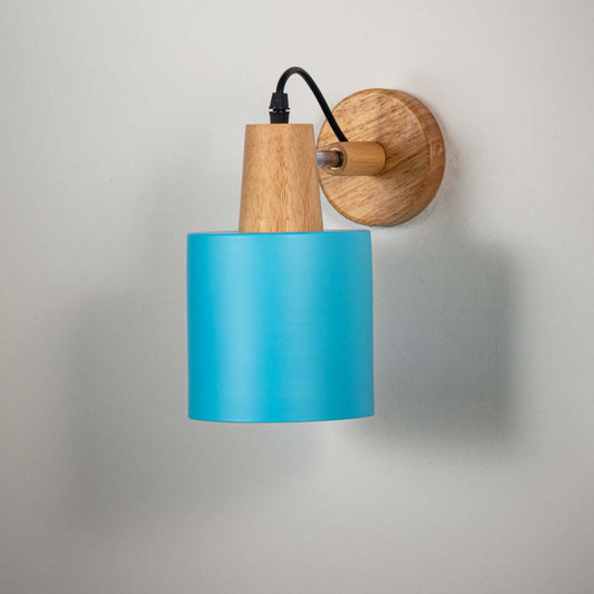Blue metal wall light with wooden mount and black arm on neutral background modern cone shade design perfect for bedside lighting decor.