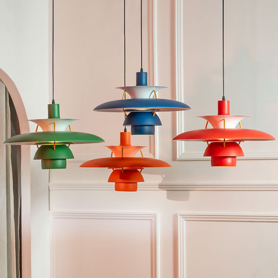 Set of multi layer pendant lights in green blue orange and red tones hanging together adding a vibrant modern touch to the interior.