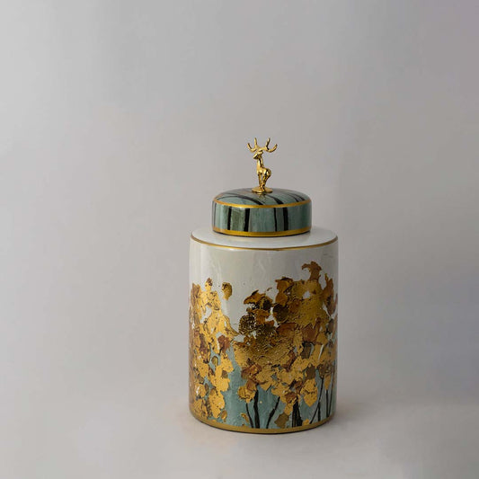 Hand painted ceramic jar with teal lid and golden tree pattern highlighted with metallic deer figure on top.