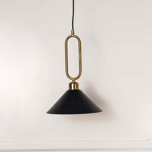 Modern black metal pendant light with gold loop handle and cone shade hanging against soft beige wall background for elegant interior decor lighting.