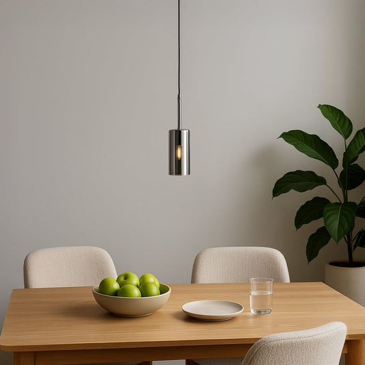 Chrome pendant light hanging elegantly above a dining table bringing a modern metallic touch to minimalist interiors.