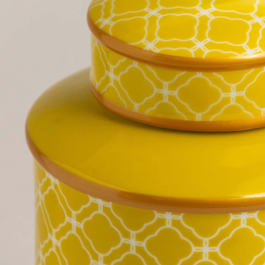 Closeup of yellow ceramic jar showing intricate lattice pattern and glossy finish for modern stylish decor.