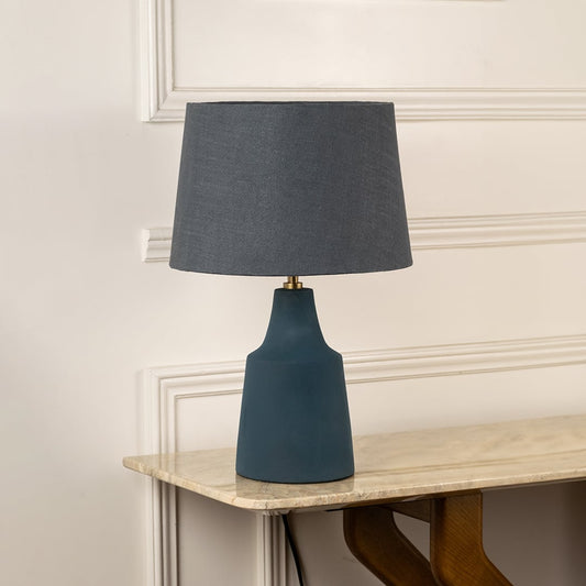Blue ceramic table lamp with black fabric shade and modern silhouette for sophisticated living room decor styling.