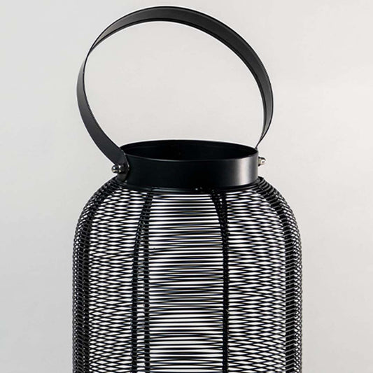 Closeup of black metal mesh lantern with curved handle for luxury tabletop decor styling use.