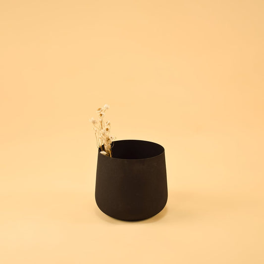 Modern black metal planter placed in a warm neutral layout adding depth and minimal charm to home styling.