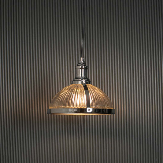 Clear ribbed glass pendant light with brushed brass finish glowing for modern interiors.