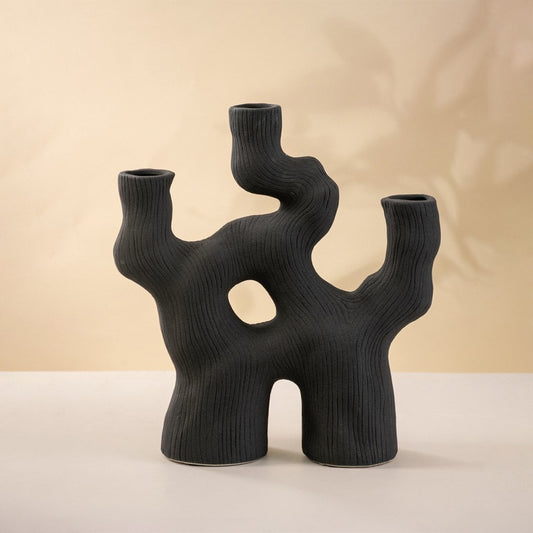 Modern black sculptural ceramic vase with three openings and artistic asymmetrical design.