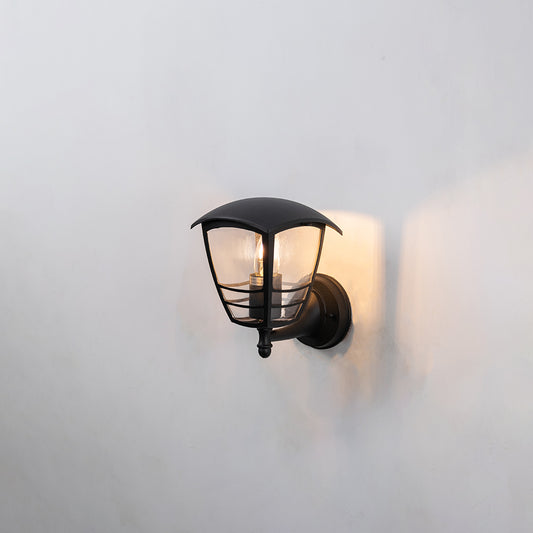 Black metal outdoor wall light on white background featuring a compact curved glass shade hood design for porch decor.