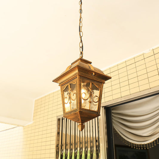 A classic golden hanging lantern with light on illuminating a tiled entrance area and enhancing the warm welcoming ambiance with its ornate metalwork and glowing glass panels.