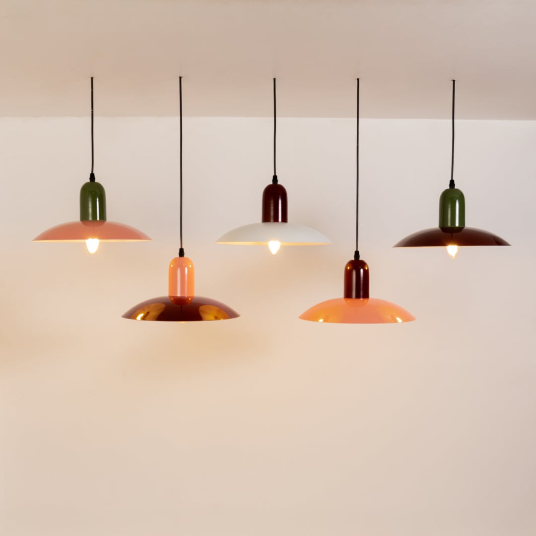 Red metal pendant lights with peach tops arranged together for modern kitchen dining and stylish living room decor.