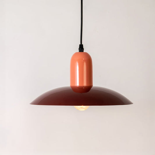Red metal pendant light glowing softly with peach top on white background for modern kitchen dining and living room decor.