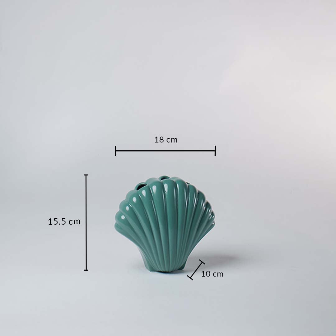 Teal ceramic shell shaped vase shown with dimensions 18 cm width 15.5 cm height and 10 cm depth giving a clear idea of its compact size.