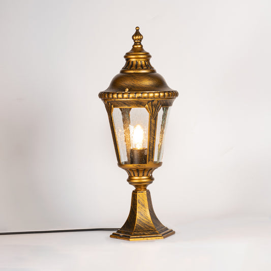 Antique gold outdoor gate light with glowing glass shade for luxury exterior decor styling use.