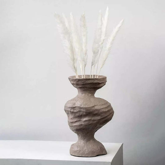 White dried pampas grass stems arranged in a sculpted brown vase creating a fluffy pampas décor accent ideal for boho home décor natural modern interiors and soft neutral styling.