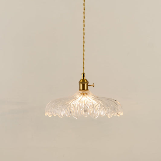 Gold metal pendant light with textured glass shade illuminated to showcase elegant decorative ceiling lighting appeal.