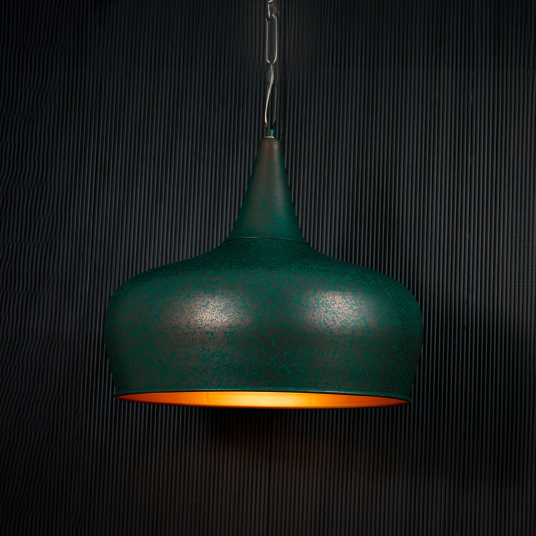 Green metal pendant light with matte textured finish adding modern charm to home interiors.