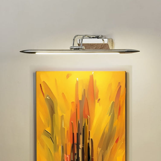 Lifestyle closeup of chrome metal picture light enhancing artwork with warm focused directional illumination.