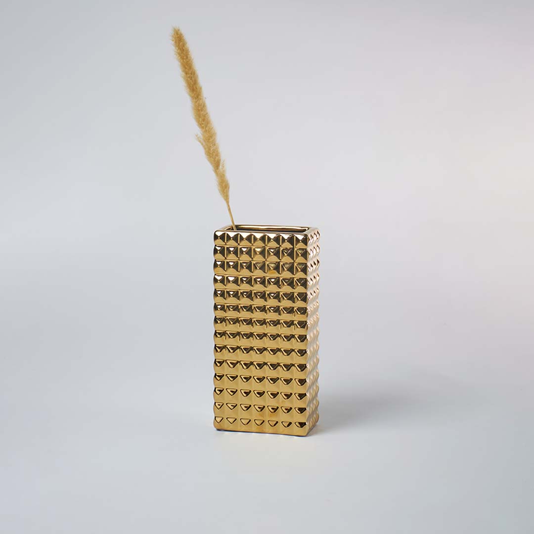 Modern gold textured vase placed in a minimal setting creating a bold metallic decor accent perfect for contemporary living spaces.