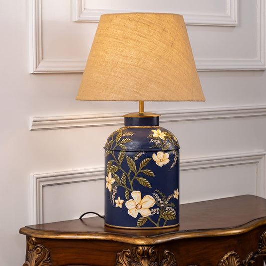 Plumeria blue table lamp on white background glowing softly with floral pattern and refreshing interior lighting appeal.