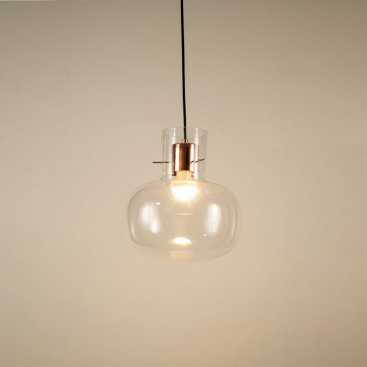 Transparent glass hanging pendant light glowing softly on white background for elegant and modern room ambience.