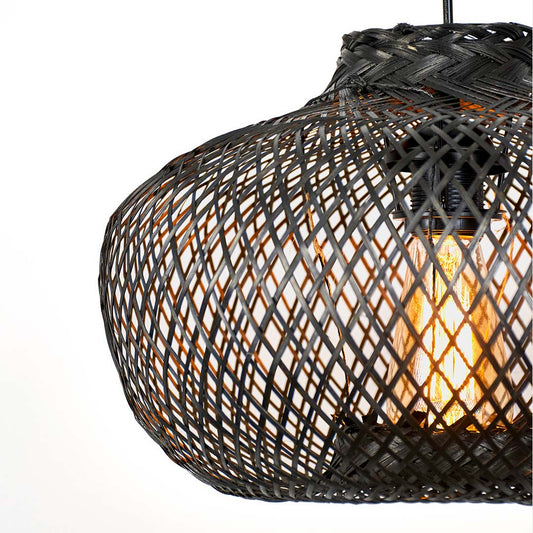 Black metal mesh pendant light with rounded form and open weave structure showing warm bulb glow hanging against neutral wall background for industrial decor.