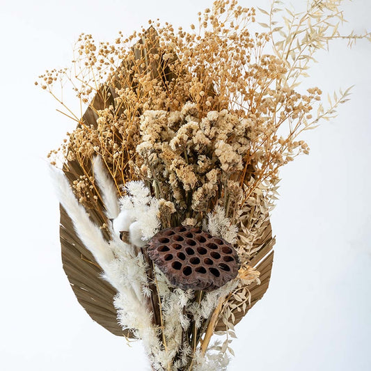 Preserved dried flower bouquet with lotus pod pampas textures and natural beige elements highlighting rustic decor style.