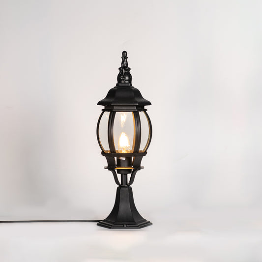 Vintage black outdoor gate light with warm glowing bulb for elegant exterior decor styling use.
