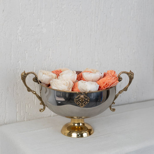 Silver pedestal bowl with gold accents packed inside a black branded gift box with open lid shown on white surface.