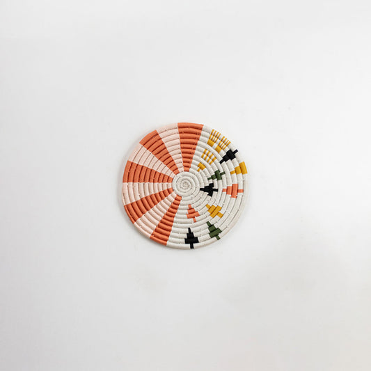 White and orange decorative wall plate with geometric sunburst pattern for artistic wall styling and home decor.