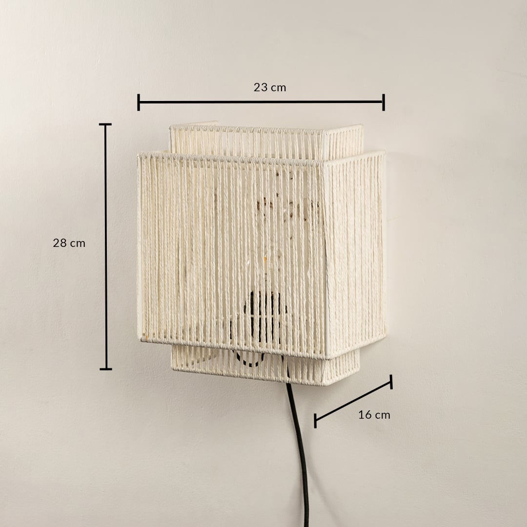 Handwoven jute wall light measuring 28 x 23 x 16 cm combines earthy texture and modern shape ideal for ambient lighting.