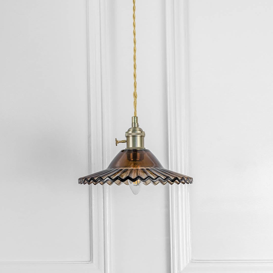 Bronze fluted metal pendant light with antique brass fittings crafted for elegant dining spaces.
