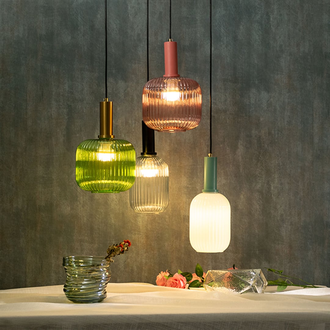 Modern ribbed glass pendant lights in green pink clear and white shades hanging together for elegant home lighting.