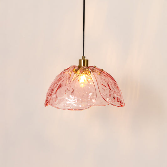 Decorative pendant light in gold metal finish with pink glass shade for dining room or kitchen decor lighting white background.