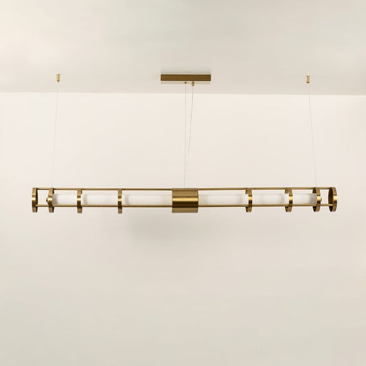 A gold linear ceiling fixture with symmetrical cylindrical elements ideal for modern LED chandelier lighting and luxury designer interior décor applications.
