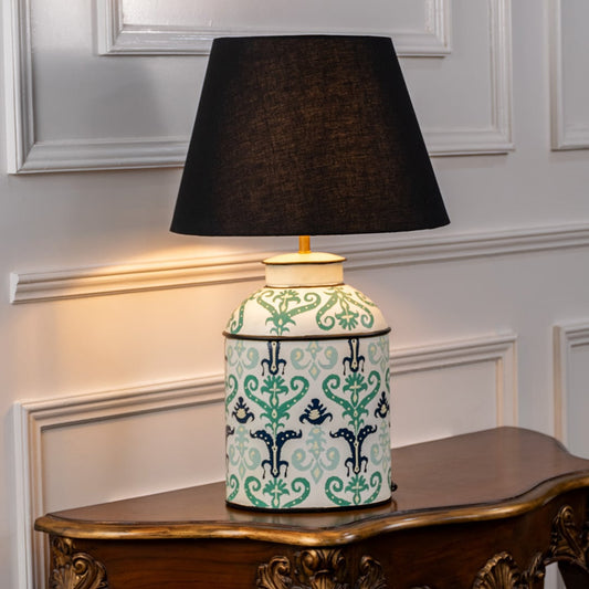 Table lamp on white background showcasing mint green ceramic base with traditional floral motifs paired with a black fabric lampshade.