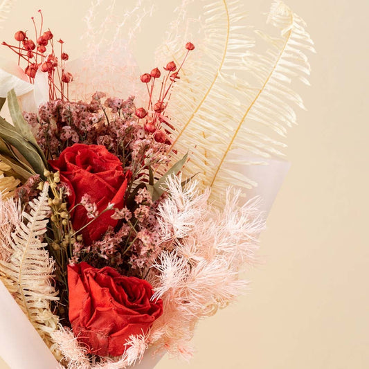 Closeup of Infinity Rose Red bouquet showing dried eucalyptus red infinity rose fern asparagus and crystal grass.