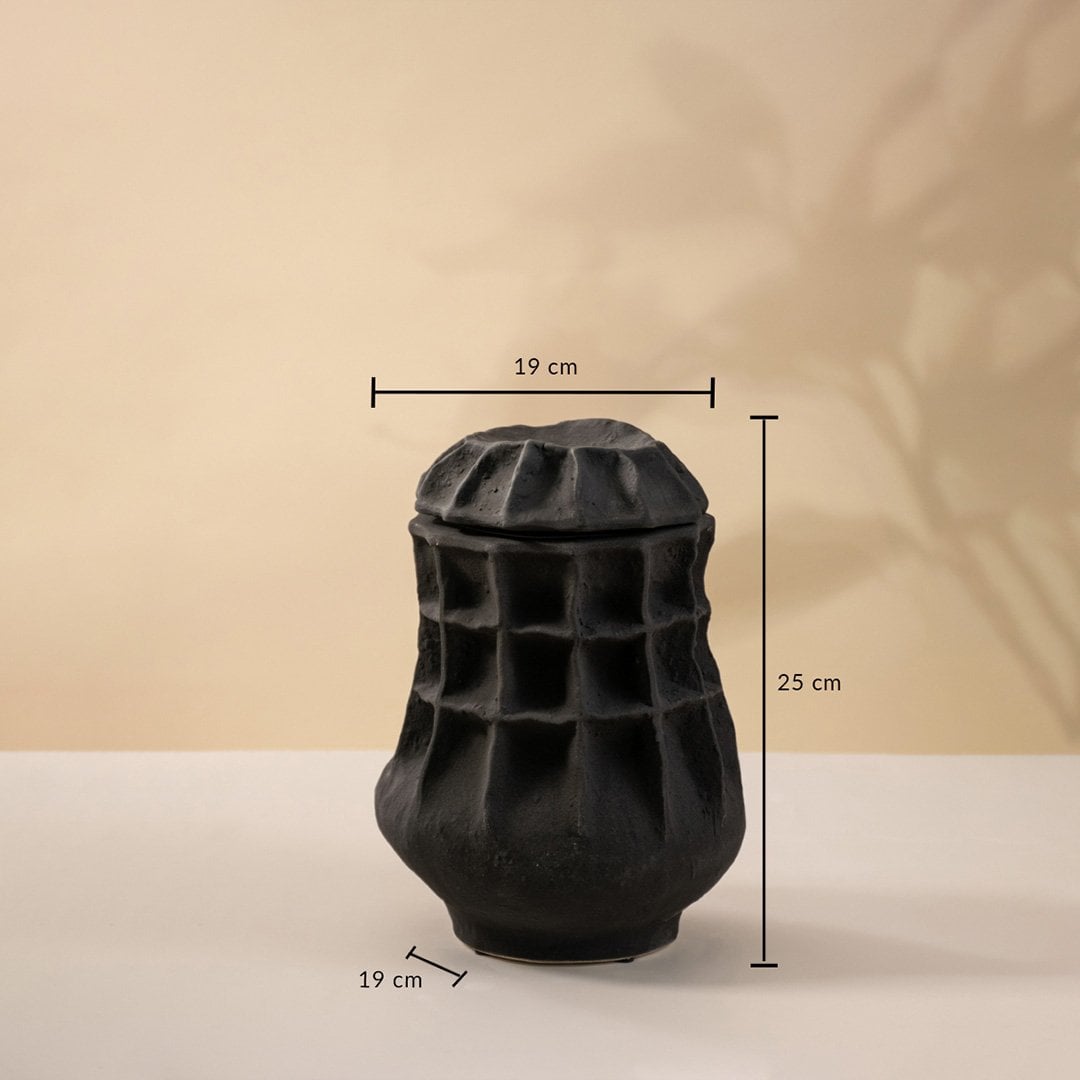 Black sculptural vase shown on a neutral surface measuring 25 cm in height and 19 cm in width.