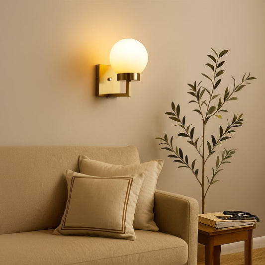 Gold metal wall light with frosted glass globe shade styled in a modern room adding warm ambient lighting for bedrooms hallways and living spaces.