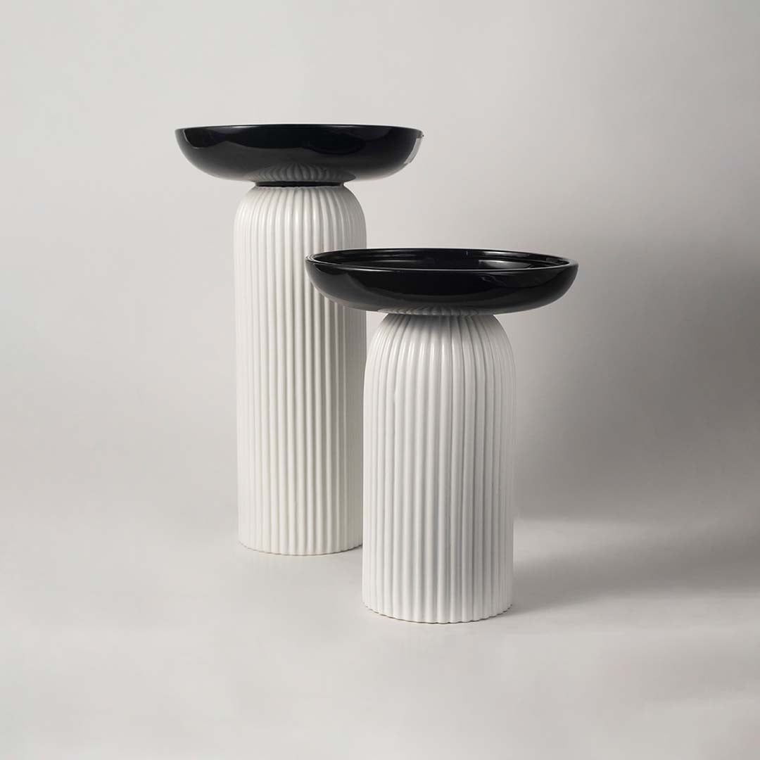 A stylish pedestal bowl in black and white shown in a grouped decor setup adding a bold contemporary touch to modern home styling.