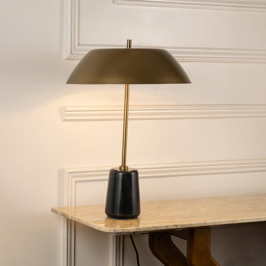 Table lamp with gold metal base and wide shade perfect for bedroom or living room table decor styling on clean white background.