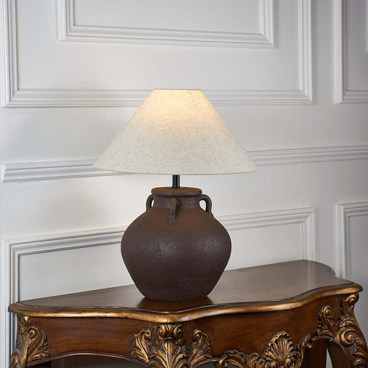 Brown ceramic table lamp with beige linen shade glowing on white background ideal for bedroom lighting table lamp.