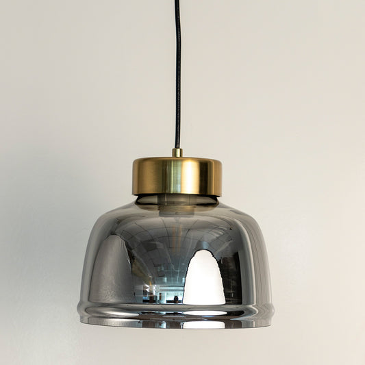 Smoky grey glass pendant light with polished gold accents crafted for modern living spaces.