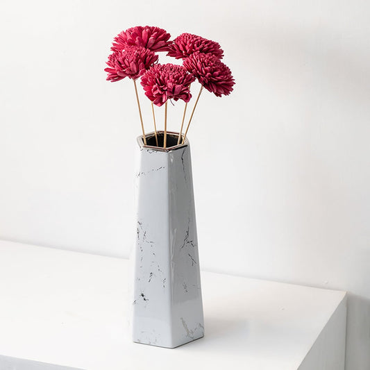 Pink sola flower sticks in a tall marble effect vase with artificial decorative flowers for home office and event decor.