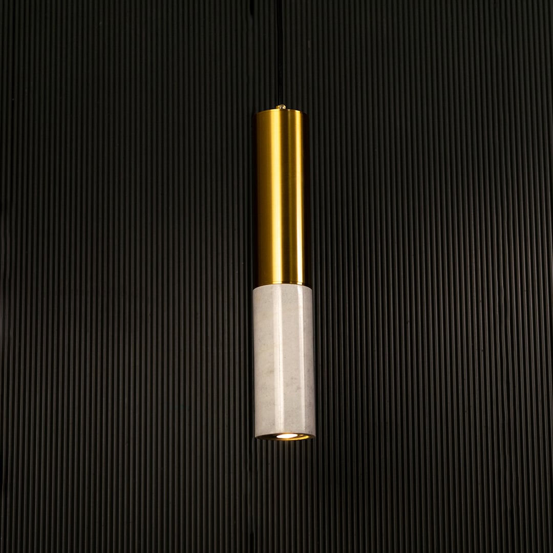 White marble and metal cylinder pendant light hanging against dark textured wall with light off for clean elegant décor.